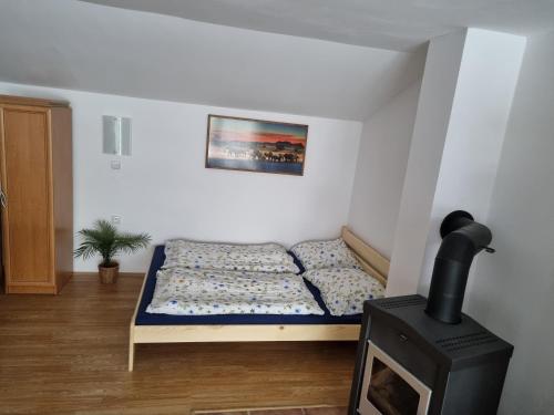 a bed in a room with a stove at Penzion U našich in Mladé Buky