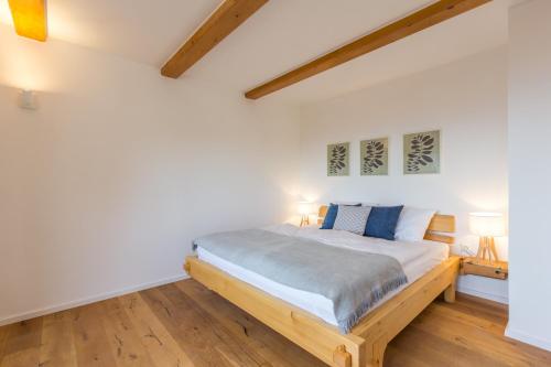una camera da letto con pareti bianche e un letto in legno di Vilaraj a Maribor