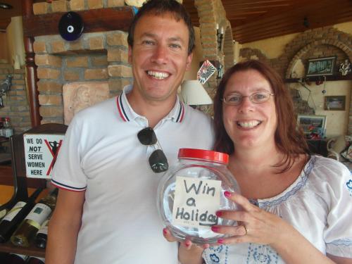 a man and a woman holding a jar with a sign on it at Beach House Hotel in Side