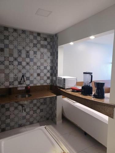 a kitchen with a sink and a microwave on a counter at Victory Flat Tambaú BR in João Pessoa