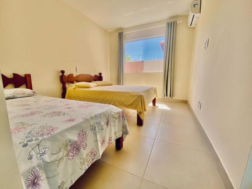 卡馬薩里的住宿－Casa Jacuípe，酒店客房设有两张床和窗户。