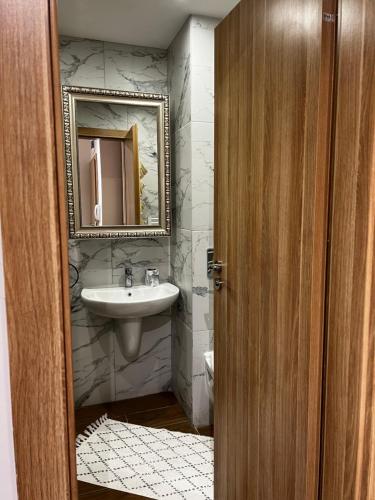 a bathroom with a sink and a mirror at Borovets Gardens one bedroom apartment in Borovets