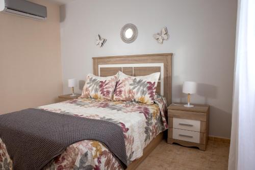 ein Schlafzimmer mit einem Bett und einer Uhr an der Wand in der Unterkunft Apto ISA: amplio y acogedor apto de 75m con terraza, aire acondicionado y parking gratuito in Los Abrigos