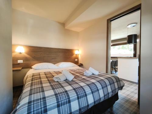 a bedroom with a bed with a plaid blanket at Hostdomus - Helsinki Suite in Sestriere