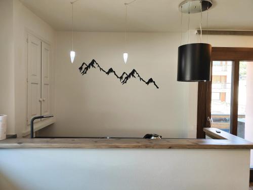a kitchen with a counter with a mountain mural on the wall at Hostdomus - Helsinki Suite in Sestriere