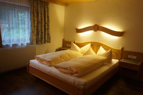 Un dormitorio con una cama con una luz en la pared. en Apart Martha, en Zellberg