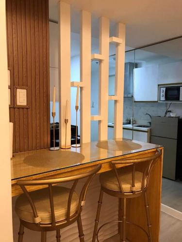 a kitchen with a wooden table and two chairs at Chic Hideaway at Azure North Bali Tower in San Fernando