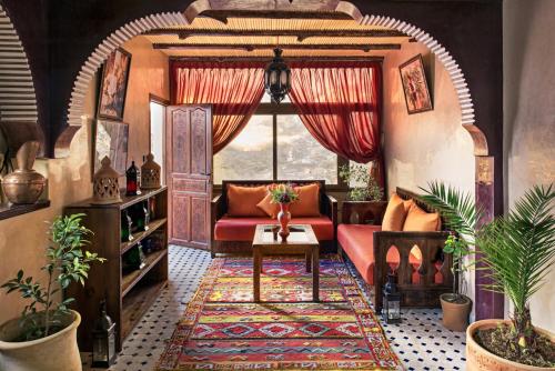 a living room with a red couch and a window at Atlas Prestige in Imlil