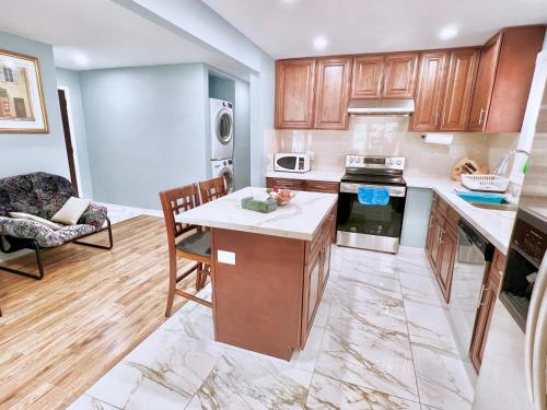 Renovated Rooms 10-min to Finch Subway Near Yonge St في تورونتو: مطبخ مع خزائن خشبية وطاولة وكراسي