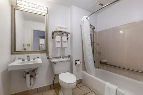 a bathroom with a toilet and a sink and a tub at Quality Inn Near Fort Liberty formerly Ft Bragg in Fayetteville