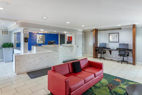 a lobby with a red couch and a bar at Quality Inn Fayetteville near Fort Bragg in Fayetteville