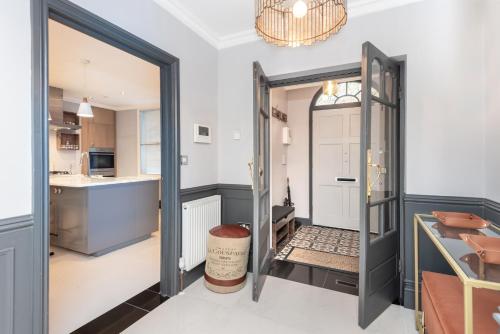 a kitchen and dining room with a door open to a kitchen at The London House - Entire Villa in London