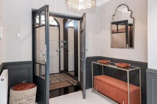 a bathroom with a mirror and a stool at The London House - Entire Villa in London