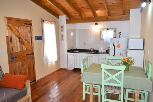 a kitchen with a table and chairs and a refrigerator at Cabañas Cuncumen in Tandil