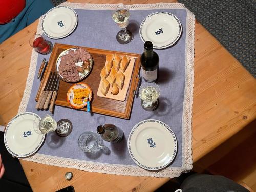 a table with plates and food and a bottle of wine at Blockhaus Semmering in Steinhaus am Semmering