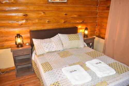 um quarto com uma cama com duas mesas de cabeceira em Cabañas Cuncumen em Tandil