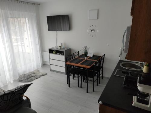 cocina y comedor con mesa y sillas en Borics Apartman, en Balatonföldvár