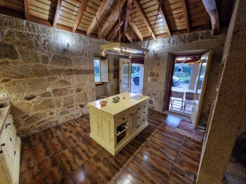 baño con lavabo y pared de piedra en Quinta do Moinho da Ínsua, en Ponte de Lima