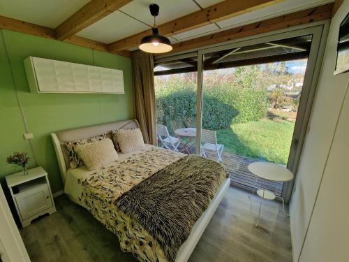 1 Schlafzimmer mit einem Bett und einem Balkon mit einem Tisch in der Unterkunft Quinta do Moinho da Ínsua in Ponte de Lima