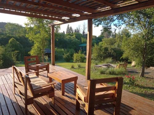 2 sillas y una mesa en una terraza de madera en Los Lirios en Los Hornillos
