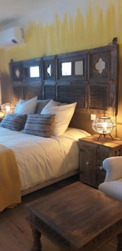 a bedroom with a bed with pillows and a table at El Violin Experiencia Adults only in Melegis