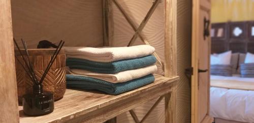 a pile of towels on a shelf in a bedroom at El Violin Experiencia Adults only in Melegis