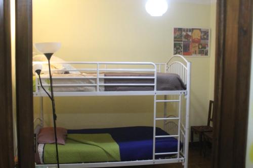 a bunk bed room with two bunk beds and a lamp at Boa Vivenda in Carcavelos