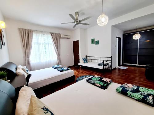 uma sala de estar com 2 camas e uma ventoinha de tecto em Ocean 25 Shamrock Beach Big Group 6 Bedroom 5 Bathroom with Pool em Tanjung Bungah