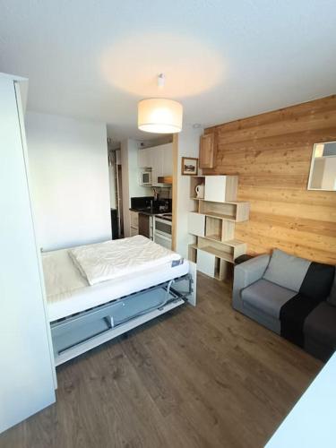une chambre avec un lit et un canapé dans l'établissement STUDIO 2 PERS PLEIN CENTRE VAL CLARET, à Tignes