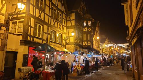 a group of people walking down a street at a market at Chambres d'Hôtes du Marché aux Grains in Bouxwiller