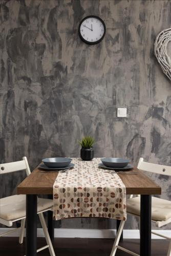a dining room table with chairs and a clock on a wall at Apartment Viksa with Jacuzzi in Zagreb