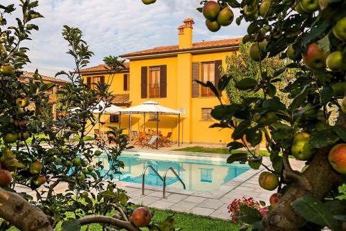 a yellow house with a swimming pool in front of it at Casa Galina in Ciggiano