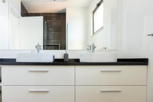 two sinks in a bathroom with white cabinets at 3 bdr aprt, best seaview, rooftop pool - LCGR in Praia