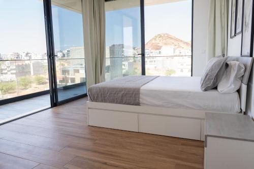 een slaapkamer met een bed en een groot raam bij 3 bdr aprt, best seaview, rooftop pool - LCGR in Praia