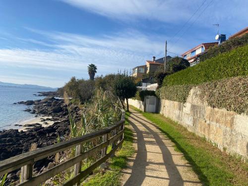 un sentiero vicino a una recinzione vicino all'oceano di Covelodge - Piso a pocos metros de la playa a Pontevedra