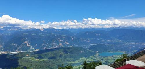 a view of a valley with mountains and a lake at PanoramaHotel Penegal in Mendola