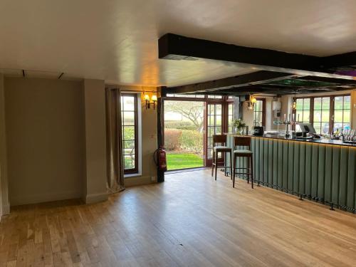 an empty living room with a counter and a kitchen at Tottington Manor Hotel in Henfield