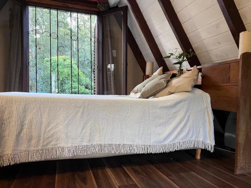 ein Schlafzimmer mit einem Bett und einem großen Fenster in der Unterkunft Cabaña Alpina del bosque! in Mar del Plata