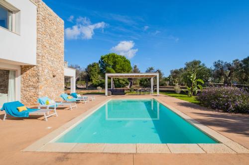 a swimming pool with chairs and a gazebo at Villa Agape Luxury Leuca by HDSalento in Leuca