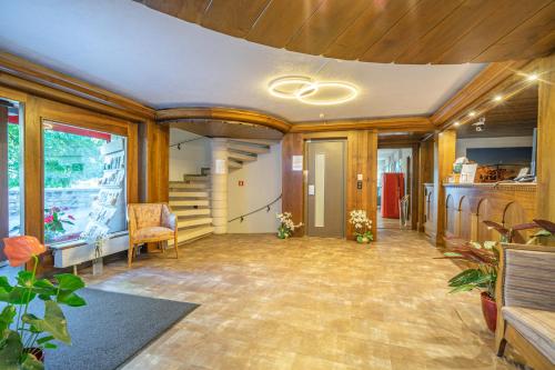 a large room with wooden walls and a spiral staircase at Schlosshotel - Self Check-In Hotel in Brig