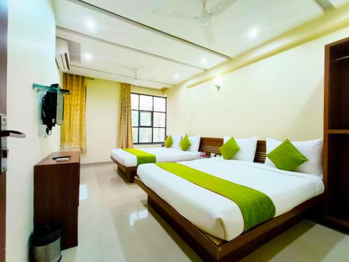 a bedroom with two beds and a window at SAI SRUSHTI by NEEM SQUARE in Shirdi