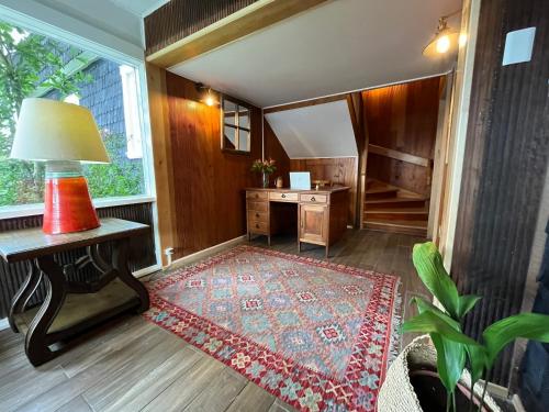 - un salon avec un bureau et un tapis dans l'établissement Casa Ellies Hotel Boutique, à Puerto Varas