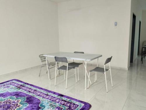 a white table and chairs and a purple rug at Mahzan Homestay in Jitra