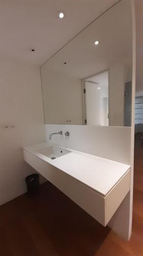 a white bathroom with a sink and a mirror at Koko in Larnaca