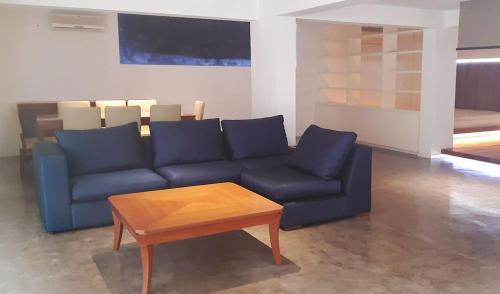un soggiorno con divano blu e tavolo di Koko a Larnaka