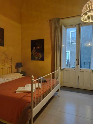 a bedroom with a bed and a large window at I Vespri in Catania