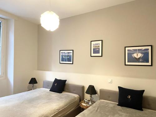 1 dormitorio con 2 camas y 2 lámparas en la pared en Cannes Old Port, Seafront & Seaview , fast wifi, best AC en Cannes