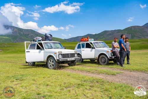 a group of people standing next to two white trucks at Zaur Guest hause in Xınalıq