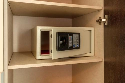 a white microwave on a shelf in a kitchen at Hotel Best Night 2 in Alger