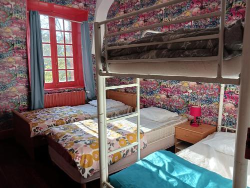 two bunk beds in a room with floral wallpaper at chateau du ponthereau in Massay